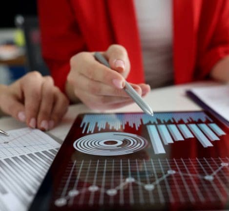 Business women studying charts and diagrams on digital tablet closeup. Business meetings concept